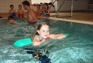 Mädchen mit Schwimmhilfe im Anfängerkurs