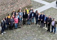 Gruppe in Schlosshof blickt nach oben in Kamera