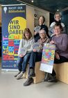 Menschen mit Broschüren für die Nacht der Bibliotheken
