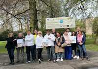 Sportler*innen und Sponsoren vor Plakat im Schlosspark Neersen