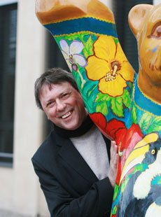 MdB Uwe Schummer schaut freundlich hinter Bärenfigur hervor 