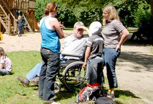 Rollstuhlfahrer, ein Kind und zwei Frauen im Park
